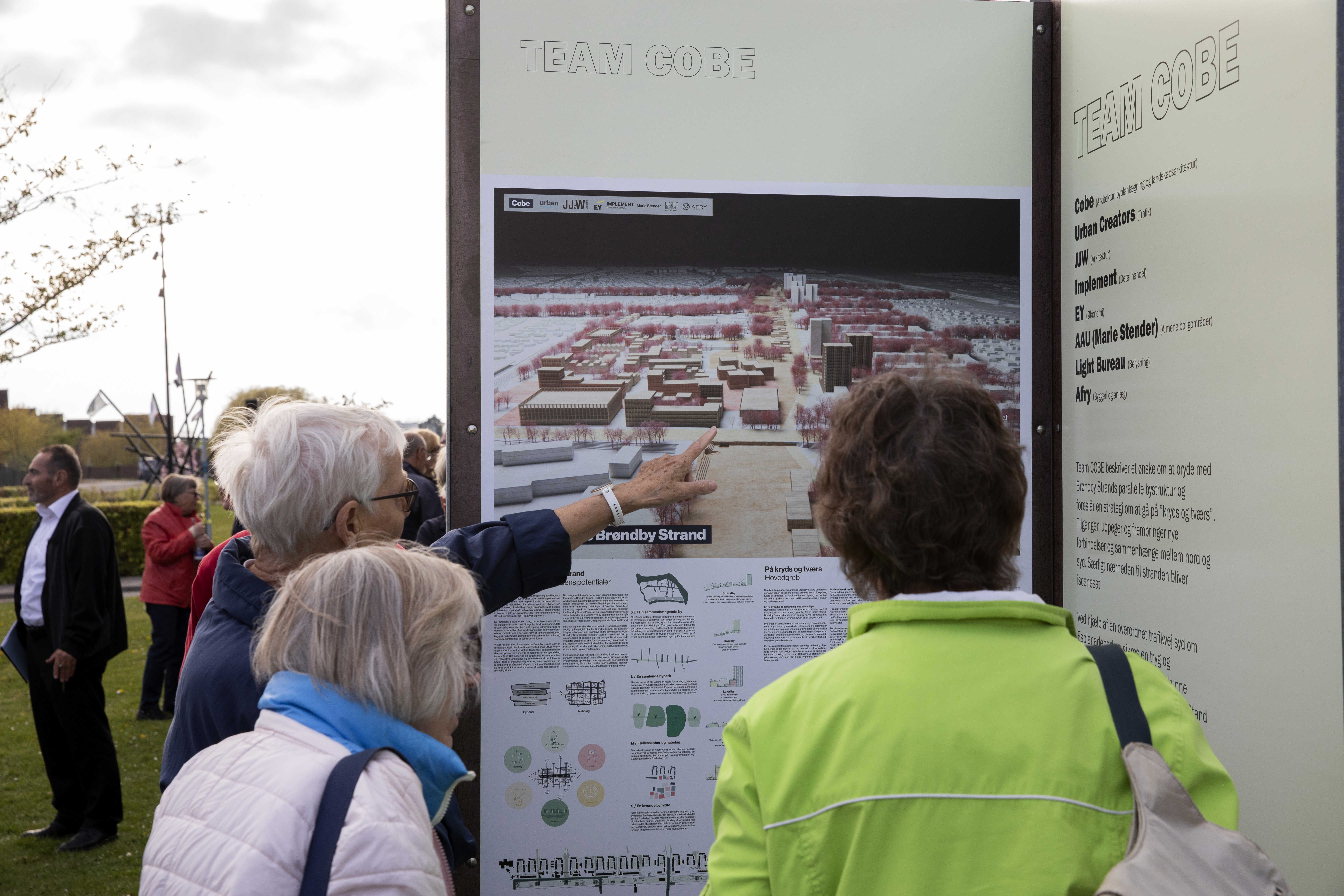 Borgere kigger og peger på plancher af forslag til udviklingsplanen